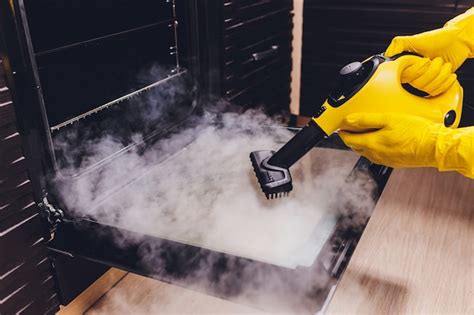 Premium Photo | Steam cleaning oven house cleaning hand close-up.