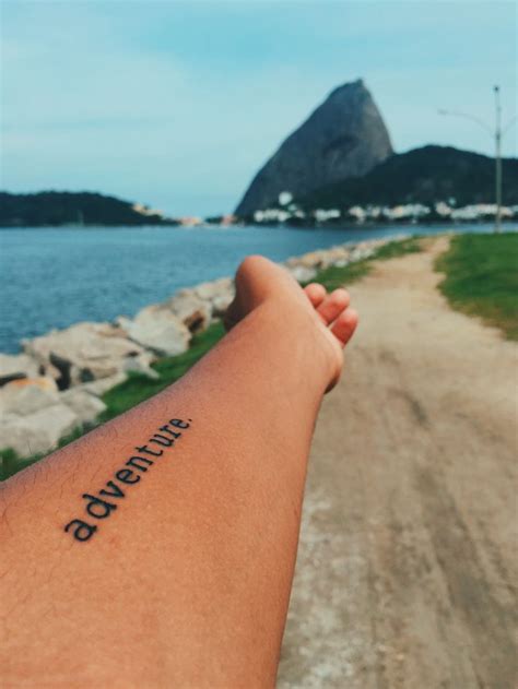 a person's arm with the word adventure written on it, in front of a ...