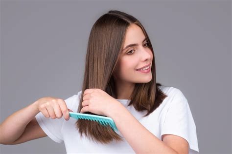 Premium Photo | Portrait of beautiful young woman combing her hair ...