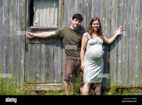 Husband with pregnant wife in front of their old house Stock Photo - Alamy