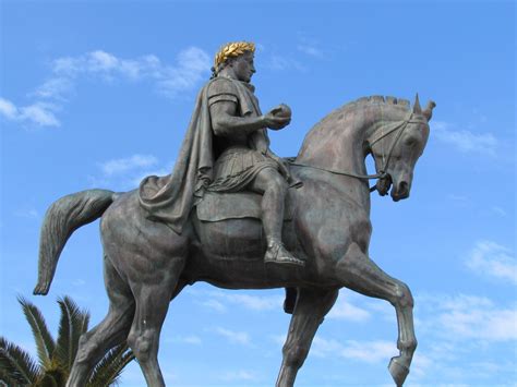 a statue of a man riding on the back of a horse in front of a blue sky