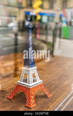 A small-scale model of the eiffel tower standing on a map of Paris ...