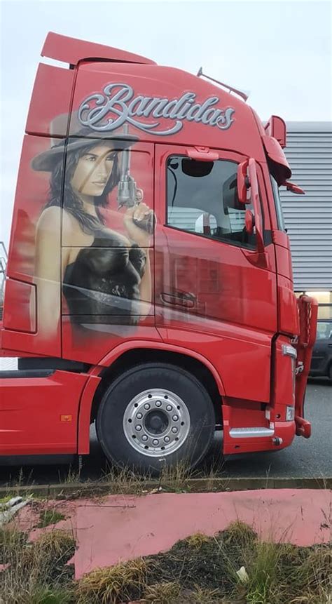 a red semi truck parked in front of a building