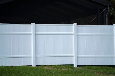 Premium Photo | White vinyl picket fence on green lawn surrounding property grounds for backyard ...