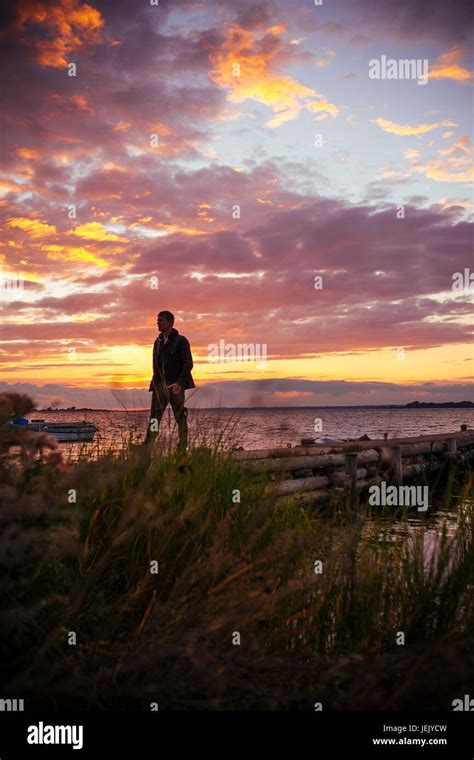 Man walking at sunset Stock Photo - Alamy