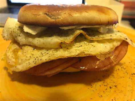 Toasted bagel, cream cheese, two eggs over hard with salt and pepper, and fried honey ham ...