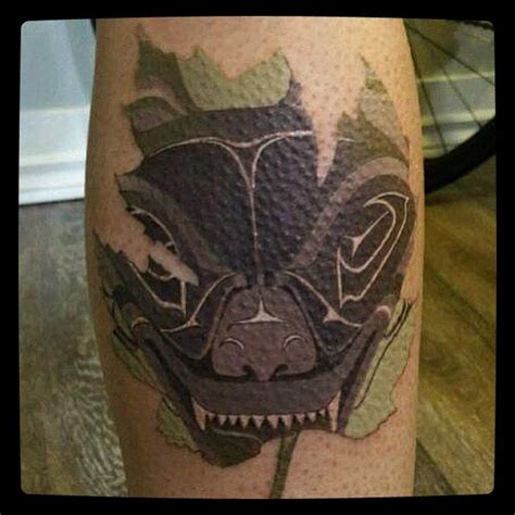 a close up of a person's leg with a tattoo design on the leg