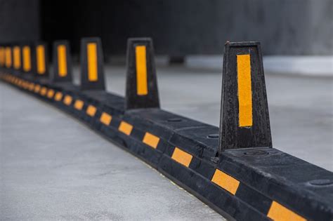 Premium Photo | Road dividers with yellow stripes on road to underground garage