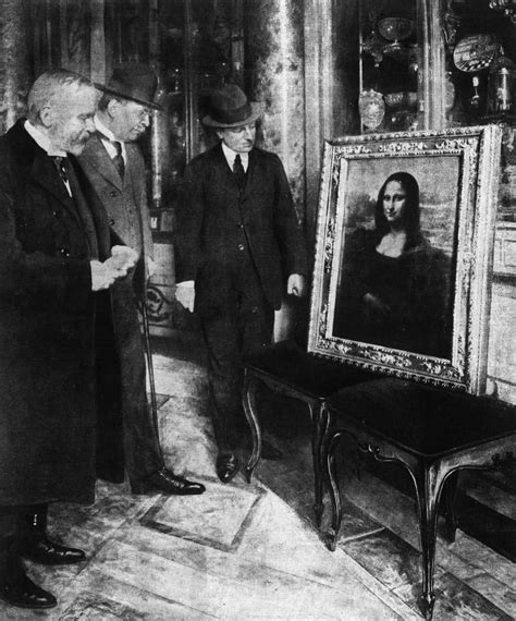 black and white photograph of two men standing in front of an old painting with a woman's face on it