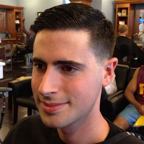 This is a classic taper. The hair is cut aggressively close around the sides and back (a close ...