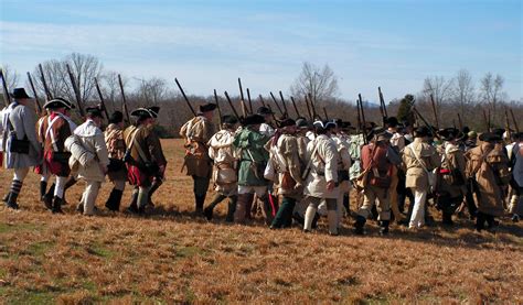 a group of men dressed in period clothing standing next to each other ...