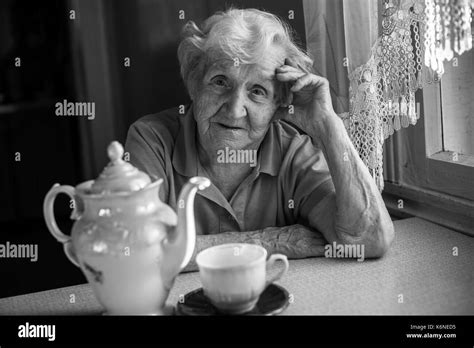Mature woman sitting holding water Black and White Stock Photos & Images - Alamy