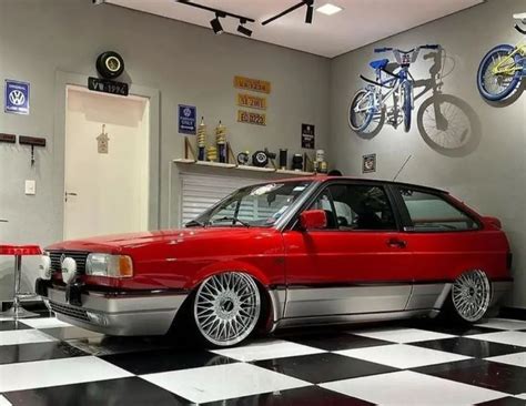 a red car parked in a garage next to a checkered floor