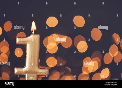 Gold number 1 celebration candle against blurred light background Stock Photo - Alamy