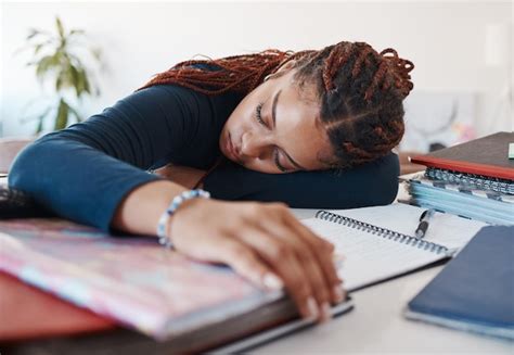 Premium Photo | Tired student sleeping at her desk while studying for university or college ...