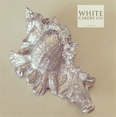 a white cakery co brooch sitting on top of a table