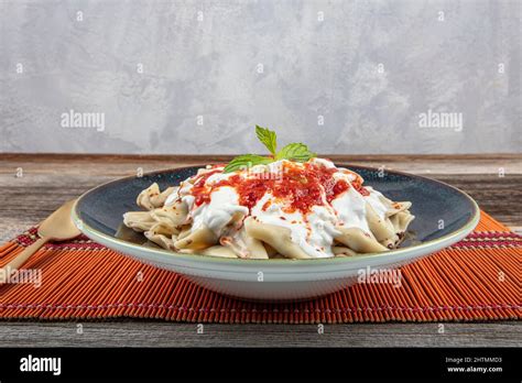 Plates of traditional Turkish food. Turkish Ravioli (Mantı) with yoghurt and tomato sauce Stock ...