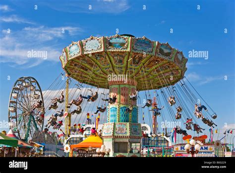 Carnival swing ride with kids and families having fun. Blue sky Stock Photo - Alamy