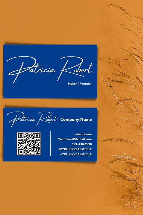 two business cards sitting on top of each other in front of a brown background with blue writing