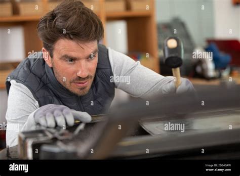 coachbuilder using a hammer to bend a car door Stock Photo - Alamy