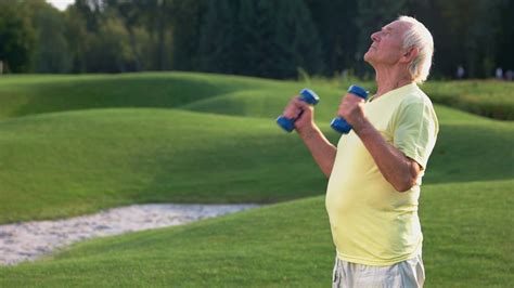 Elderly man with dumbbells. Male doing exercise outdoor. Healthy joints ...