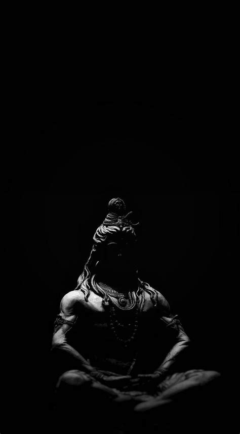 black and white photograph of a woman sitting in the dark with her hands behind her head