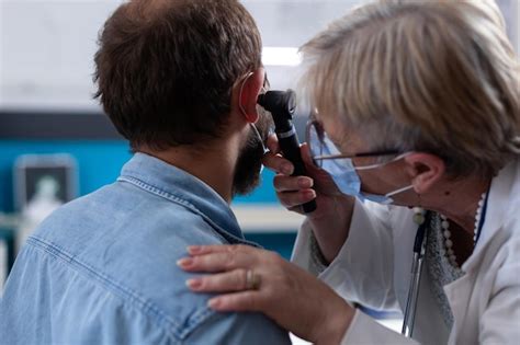 Premium Photo | Doctor ent checking ear with otoscope to woman patient