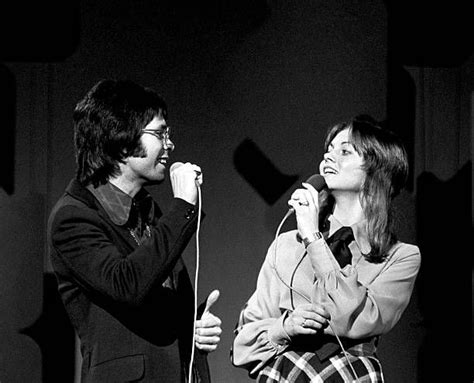 a man and woman standing next to each other while holding microphones in their hands