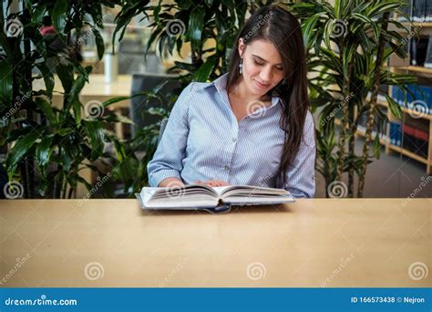 Young Man Reading Book in Public Library Stock Photo - Image of indoors, adult: 166573438