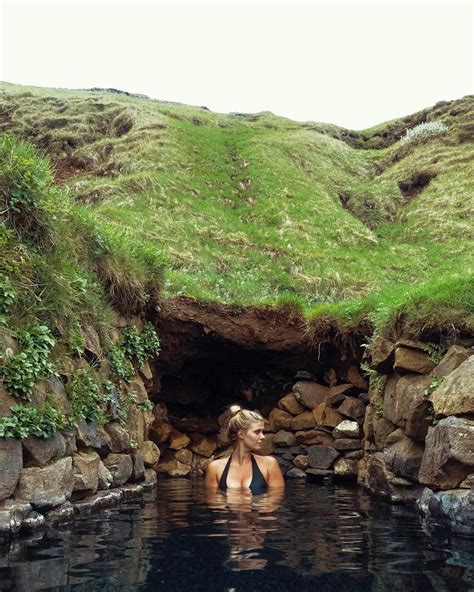 a woman is in the water near some rocks