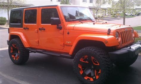 an orange jeep is parked on the street