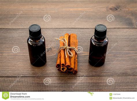 Cinnamon Oil for Cooking, Aromatheraphy, Skin Care. Bottles Near Cinnamon Sticks on Dark Wooden ...