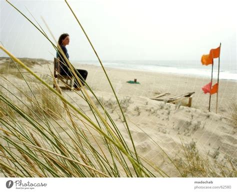 Young woman sitting alone on the beach and has wanderlust - a Royalty Free Stock Photo from ...