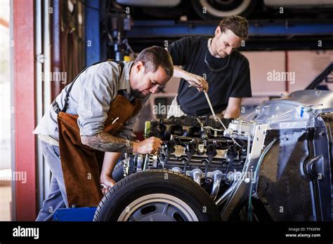 Mechanics repairing car engine in auto repair shop Stock Photo - Alamy