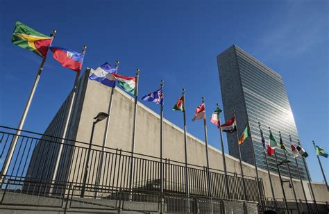 Low angle view of united nations and national flags against blue sky - StockFreedom - Premium ...