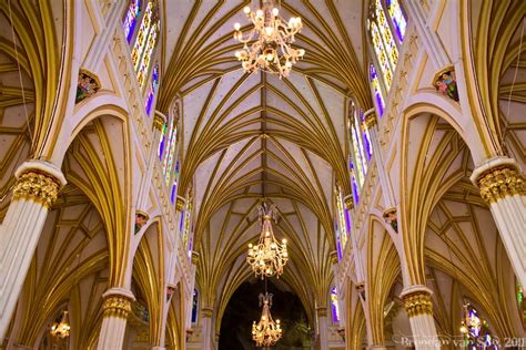 the inside of a cathedral with chandeliers and stained glass windows