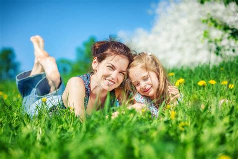 Young Woman and Her Daughter on Green Summer Grass Stock Image - Image of little, mother: 144453277