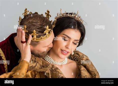 king with crown hugging and kissing attractive queen isolated on grey Stock Photo - Alamy