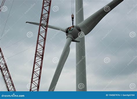 The Rotor With Rotor Blades Of The Wind Turbine Is Lifted By The High Crane, The Guy Wires Are ...