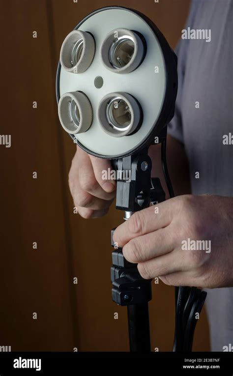 Men's Hands installs a new 4-lamp holder on a tripod. Studio lighting assembly sequence. Softbox ...