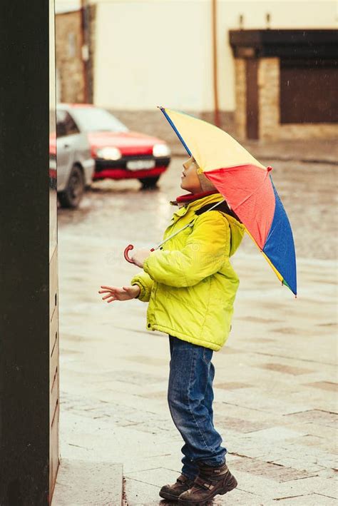 Happy Boy Walking in City with Colorful Rainbow Umbrella during Rainy Autumn Day. Cold Rainy ...