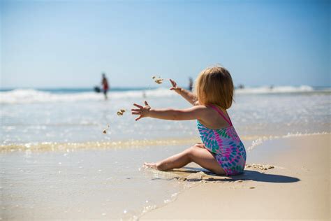 Toddler Girl Sitting on Shore during Day · Free Stock Photo