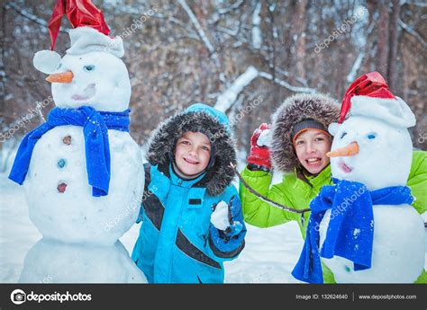 Fun, happy kids playing with snowman Stock Photo by ©rimdream 132624640