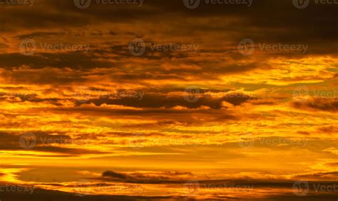 Beautiful sunset sky. Golden sunset sky with beautiful pattern of clouds. Orange, yellow, and ...