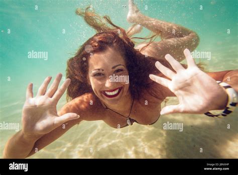 Beautiful young woman diving underwater in the sea. Looking at camera Stock Photo - Alamy