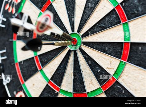 Dart board with three darts in bullseye Stock Photo - Alamy