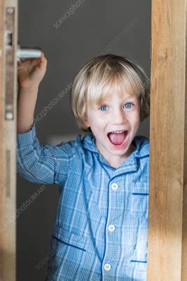 Boy opening a door - Stock Image - C034/0848 - Science Photo Library