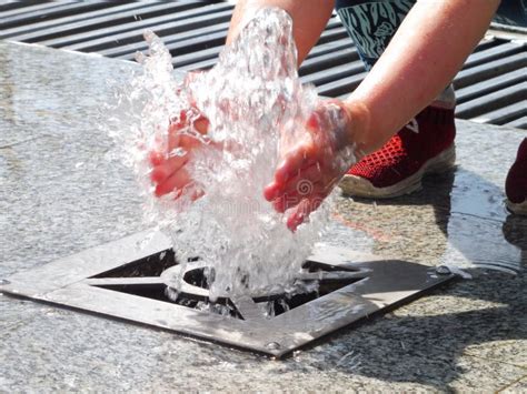 Hands Catch Water Trickling Water from the Ground Fountain Stock Photo ...