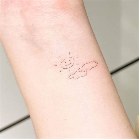 Fine line sun and cloud tattoo done on the wrist,