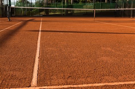 Cancha de tenis de arcilla (tierra), bajo la puesta de sol. | Foto Premium